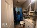 Bathroom with shower/tub combo, white vanity, and shelving at 4651 Maplelawn Dr, Columbus, IN 47203