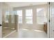 Bright bathroom with a glass enclosed shower, multiple windows, and light tile flooring at 525 Gilder Dr, Carmel, IN 46032