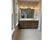 Bathroom with double vanity, wood cabinets, large mirror, decorative lighting, and tiled floors at 525 Gilder Dr, Carmel, IN 46032