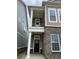 Close-up of the home entrance featuring a dark front door, white columns, and brick and siding exterior at 525 Gilder Dr, Carmel, IN 46032