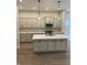 Modern kitchen with gray cabinets, stainless steel appliances, quartz countertops, and hardwood flooring at 525 Gilder Dr, Carmel, IN 46032