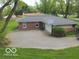 Rear exterior featuring a two car garage with a basketball hoop and parking at 5420 Skyridge Dr, Indianapolis, IN 46250