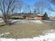 Brick ranch home with snow-covered lawn and mature trees at 5420 Skyridge Dr, Indianapolis, IN 46250
