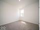 A bright bedroom with neutral carpet, white walls, and a window offering natural light at 6033 Granby Dr, Whitestown, IN 46075