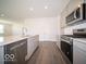 Open-concept kitchen with stainless steel appliances, an island, gray cabinets, and wood-look flooring at 6033 Granby Dr, Whitestown, IN 46075