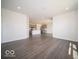 Open-concept living area with dark wood-style floors leads into a modern kitchen space at 6033 Granby Dr, Whitestown, IN 46075