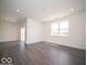Large living room with wood-style floors, sliding glass doors, and ample natural light at 6033 Granby Dr, Whitestown, IN 46075