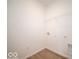 Neat laundry room with wood-look floors, white walls, and a wire shelf at 6047 Granby Dr, Whitestown, IN 46075