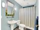 Bathroom with a pedestal sink, blue walls, decorative mirror, and shower with a patterned curtain at 6377 N Tutterow Rd, Monrovia, IN 46157