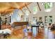 Bright, open living room with vaulted ceiling, wooden floors, a grand piano, and many windows for natural light at 6377 N Tutterow Rd, Monrovia, IN 46157