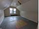 Unfinished attic bedroom with sloped ceilings and hardwood floors at 837 S Warman S Ave, Indianapolis, IN 46221
