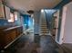 Kitchen with blue walls, damaged ceiling, and exposed staircase at 837 S Warman S Ave, Indianapolis, IN 46221
