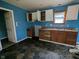Kitchen with blue walls, brown cabinets, and hexagonal tile floors at 837 S Warman S Ave, Indianapolis, IN 46221