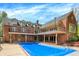Brick home backyard with a covered swimming pool and second story balcony at 8602 Frontgate Ln, Indianapolis, IN 46256