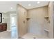 An updated bathroom features a glass-enclosed shower with a built in bench and neutral-colored tiles at 8602 Frontgate Ln, Indianapolis, IN 46256