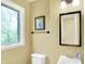 This charming bathroom features a large window, framed mirror and a ceramic pedestal sink at 8602 Frontgate Ln, Indianapolis, IN 46256