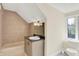 Cozy bathroom showcasing tiled shower, granite countertop vanity, and natural light from the window at 8602 Frontgate Ln, Indianapolis, IN 46256