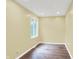 Bright bedroom features hardwood floors, neutral walls, and a window view of lush greenery at 8602 Frontgate Ln, Indianapolis, IN 46256