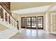 Bright foyer featuring tile flooring, staircase and large doors leading to outdoor view at 8602 Frontgate Ln, Indianapolis, IN 46256
