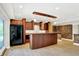 Spacious kitchen area featuring dark cabinetry, wooden bar and brick accent wall at 8602 Frontgate Ln, Indianapolis, IN 46256