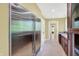 Spacious kitchen area featuring a large stainless steel refrigerator, brown cabinets, and an entrance to other rooms at 8602 Frontgate Ln, Indianapolis, IN 46256