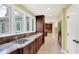 Kitchen featuring granite counters, stainless sink, custom wood cabinets, and hall access at 8602 Frontgate Ln, Indianapolis, IN 46256