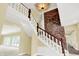 Elegant staircase with white railing, wooden handrail, and brick accent wall at 8602 Frontgate Ln, Indianapolis, IN 46256
