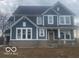 Two-story home featuring blue siding, white trim, multiple windows, and a gray brick foundation at 9497 Dogwood Dr, McCordsville, IN 46055