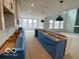 A view of the island and cabinets in this modern kitchen, leading to a spacious living area with large windows at 9497 Dogwood Dr, McCordsville, IN 46055