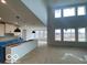 Open-concept living area with large windows, soaring ceilings, and modern pendant lighting at 9497 Dogwood Dr, McCordsville, IN 46055