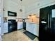 Modern kitchen with white cabinets and black appliances at 1842 Queensbridge Dr, Indianapolis, IN 46219