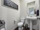 Small bathroom with pedestal sink, toilet, and framed mirror at 18655 Moray St, Westfield, IN 46069