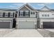 Two-story townhome with gray and white siding, gray garage door, and a brick base at 18655 Moray St, Westfield, IN 46069