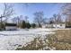 Yard with shed, partially snow-covered lawn, and trees at 233 S Routiers Ave, Indianapolis, IN 46219