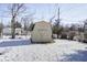 Backyard shed in snowy landscape with leaf-covered lawn at 233 S Routiers Ave, Indianapolis, IN 46219