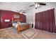 Bright bedroom with a wooden bed frame, ceiling fans, and soft carpet at 233 S Routiers Ave, Indianapolis, IN 46219