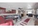 Open-concept living room with a ceiling fan connected to the kitchen with bar seating at 233 S Routiers Ave, Indianapolis, IN 46219