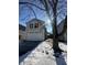 Two-story house with a white garage door, snow on the ground, and a tree in front at 2507 Redland Ln, Indianapolis, IN 46217