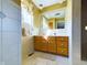 Bathroom with light beige tile, wooden vanity, and large mirror at 2509 W Euclid Ave, Muncie, IN 47304