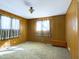 Spacious bedroom with wood paneling and neutral carpeting at 2509 W Euclid Ave, Muncie, IN 47304