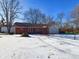 Ranch home with snow-covered yard, attached garage, and mature trees at 2509 W Euclid Ave, Muncie, IN 47304