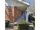 Covered front porch with white pillars, red brick exterior, and manicured hedges at 2509 W Euclid Ave, Muncie, IN 47304