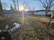 Backyard with patchy grass, some snow, and tree branches at 3130 Chrysler St, Indianapolis, IN 46224