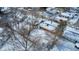Aerial shot of a cozy home nestled in a winter wonderland neighborhood from above the trees at 3647 Richelieu Rd, Indianapolis, IN 46226