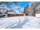 Spacious backyard featuring a brick house, mature trees and a thick blanket of winter snow at 3647 Richelieu Rd, Indianapolis, IN 46226