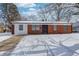Charming single-story home features brick exterior, black door and snow covered front yard at 3647 Richelieu Rd, Indianapolis, IN 46226