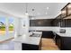 Open kitchen with a center island, dark cabinets, and natural light from large windows at 385 N Post Oak Dr, Mooresville, IN 46158