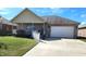 Well-kept brick home with a covered porch, white picket fence and attached garage on a grassy lawn at 5419 E Shae Lake Dr, Mooresville, IN 46158
