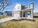 Charming two-story home featuring a two-car garage, gray brick, gray siding, a covered porch and a well-manicured lawn at 5592 Cattail Branch Ln, Clayton, IN 46118