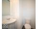 Powder Room featuring a pedestal sink, toilet, and modern gray vinyl flooring at 5592 Cattail Branch Ln, Clayton, IN 46118